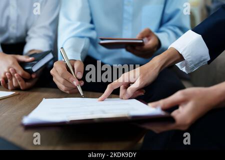 Le coppie firmano documenti importanti con gli agenti di assicurazione Foto Stock