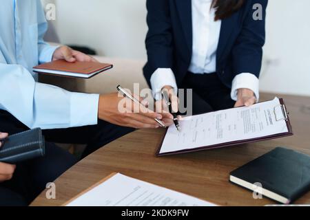Le coppie firmano documenti importanti con gli agenti di assicurazione Foto Stock