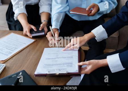 Le coppie firmano documenti importanti con gli agenti di assicurazione Foto Stock