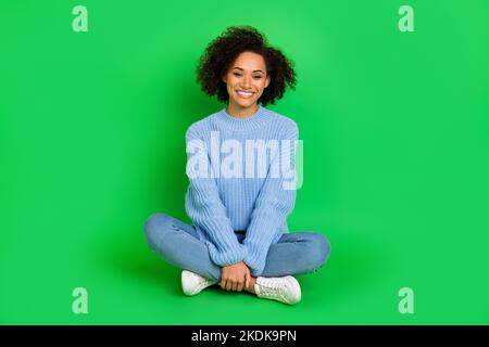 Foto di dimensioni complete di bella ragazza splendida sit pavimento hanno buon umore toothy sorriso isolato su sfondo di colore verde Foto Stock