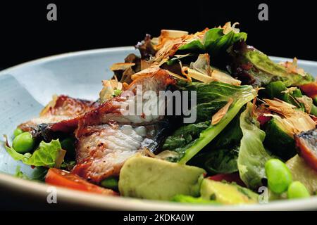 Insalata con anguilla fritta e verdure su un piatto Foto Stock