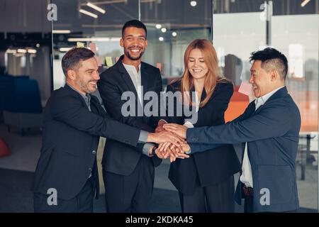 Un gruppo felice di colleghi multietnici si è Unito come concetto di unità aziendale Foto Stock