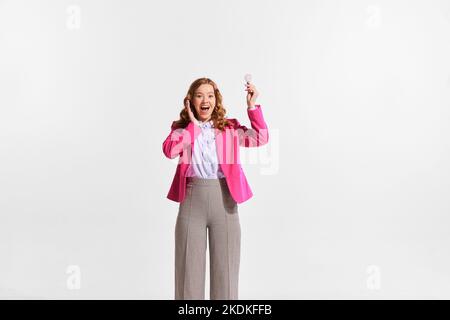 Ritratto di giovane donna felice, dipendente che tiene la lampadina simboleggia la nuova idea professionale isolato su sfondo bianco Foto Stock