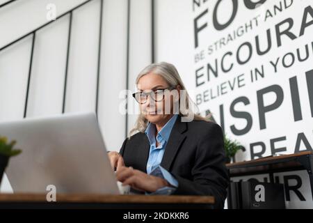 Un uomo con una malattia mentale che è depresso tiene la testa e guarda lontano prostrazione, caucasica Medio anziana imprenditrice al concetto di lavoro Foto Stock