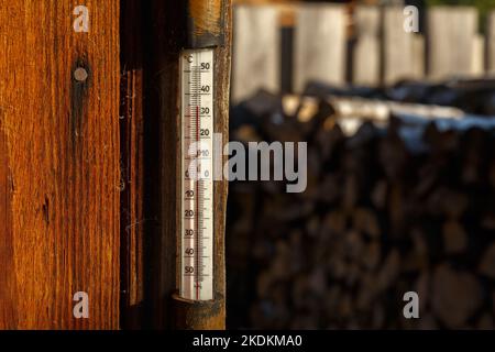 Termometro per esterni sulla parete della casa. Termometro appeso su una parete di legno in strada. Calore estivo, scala Celsius Foto Stock
