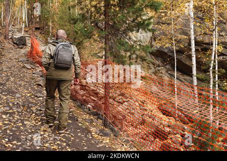 Ritratto di un uomo anziano. Un viaggio alle vecchie miniere di mica nei Monti Urali. Un turista anziano esplora le vecchie grotte abbandonate Foto Stock