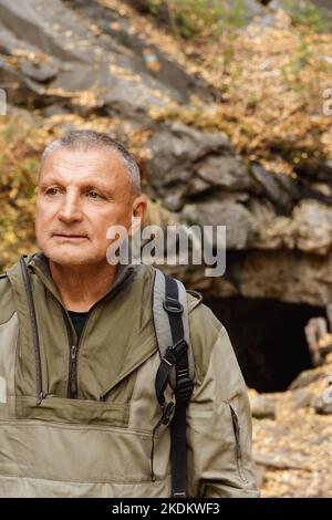 Ritratto di un uomo anziano. Un viaggio alle vecchie miniere di mica nei Monti Urali. Un turista anziano esplora le vecchie grotte abbandonate Foto Stock