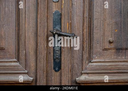 Vecchia porta d'ingresso in legno con maniglia d'antiquariato nera Foto Stock