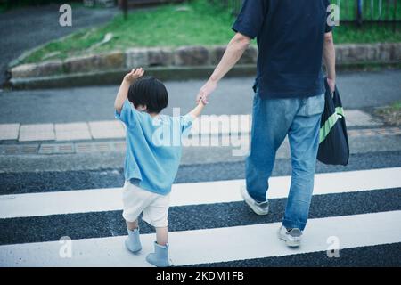 Bambino giapponese che gioca all'aperto in una giornata di pioggia Foto Stock