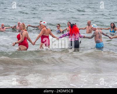 New York, New York, Stati Uniti. 6th Nov 2022. La stagione invernale inizia per il Coney Island Polar Bear Club con temperatura dell'aria 66 e temperatura dell'acqua 60,6 a Bklyn. I membri del club per il nuoto invernale hanno preso alla domenica di novembre, dove il clima è stato particolarmente caldo. Surf Atlantico come gli onlookers li hanno allietati dalla spiaggia e passerella. Nuotatori che prendono il tuffo nell'acqua warmish che tiene le mani. (Credit Image: © Milo Hess/ZUMA Press Wire) Foto Stock