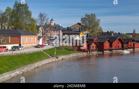 Porvoo, Finlandia - 7 maggio 2016: Paesaggio della città di Porvoo con case di legno rosso in piedi lungo la costa del fiume, gente comune a piedi la strada Foto Stock