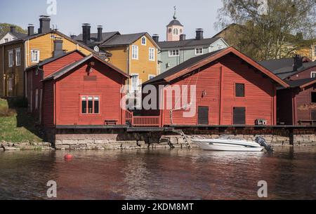 Porvoo, Finlandia - 7 maggio 2016: Vecchie case e fienili di legno rosso si trovano lungo la costa del fiume nella parte storica della città di Porvoo Foto Stock