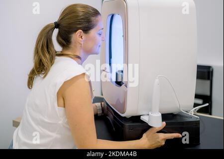 Donna che espone il viso alla luce UV Foto Stock