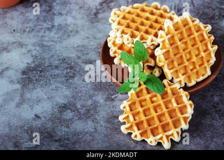 Waffle belgi su un tavolo grigio Foto Stock