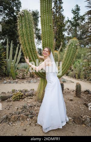 Sposa che abbraccia Saguaro Cactus Foto Stock