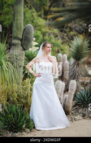 Sposa in piedi in un giardino di Cactus Foto Stock