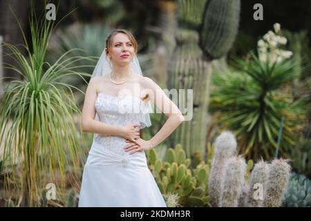 Sposa in piedi in un giardino di Cactus Foto Stock