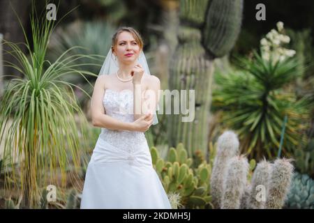 Sposa in piedi in un giardino di Cactus Foto Stock