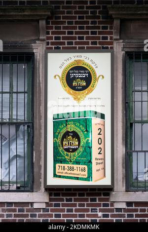 Un segno su una casa di appartamenti che sollecita la carità per i poveri in Israele. Su Hewes Street a Williamsburg, Brooklyn, New York. Foto Stock