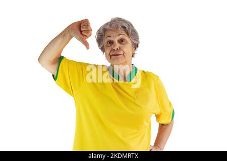 Donna matura con maglia gialla squadra di calcio isolata su bianco. Tifosi sportivi con Bandiera che festeggiano la Coppa. Foto Stock