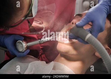 Vista dall'alto del processo di pulizia dei denti del paziente. Spazzolare i denti con getto d'acqua e detergente per saliva. Guance del riavvolgitore sulle labbra. Il concetto o Foto Stock