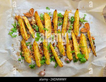 Fette di patate al forno. Cibo vegetariano. Vista dall'alto, disposizione piatta Foto Stock