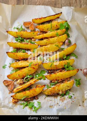 Fette di patate arrosto con prezzemolo Foto Stock