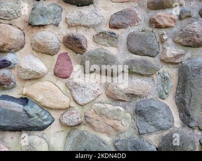 Varietà di motivi rocciosi naturali su una parete esterna Foto Stock