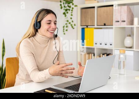 Sorridente operatrice che lavora con le cuffie del telefono nel call center Foto Stock