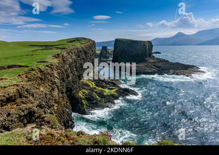 Le pile di mare di Dùn Beag e Dùn Mòr (a destra) sull'isola di Sanday, Scozia, Regno Unito, con le colline di Rum dietro. Foto Stock