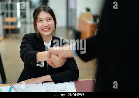 Gli imprenditori asiatici si congratulano con l'accordo tra le due aziende per aumentare gli investimenti e la forza finanziaria. Concetto di trattativa Foto Stock