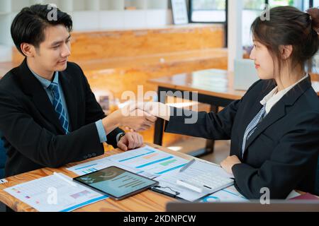 Gli imprenditori asiatici si congratulano con l'accordo tra le due aziende per aumentare gli investimenti e la forza finanziaria. Concetto di trattativa Foto Stock