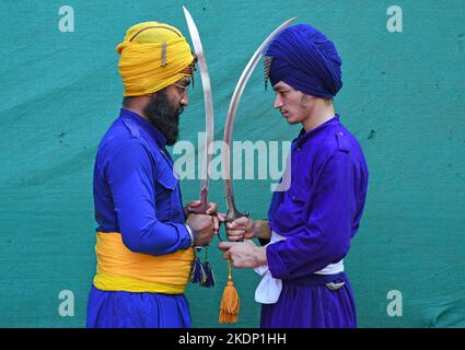 Mumbai, India. 07th Nov 2022. I guerrieri di Nichang o Sikh si posano per una foto mentre tengono le spade in vista della celebrazione del compleanno del Guru Nanak Dev Ji a Mumbai. Gatka è una parola punjabi che si traduce in bastoni di legno, che vengono usati al posto delle spade, e che usa una spada come arma principale, Tra gli altri, l'aspetto spirituale e fisico della persona si sviluppa durante la fase di apprendimento di questa antica arte. Gatka fu ampiamente utilizzato dai guerrieri Sikh per difendersi dalle atrocità dei Mughal e dei governanti britannici. Credit: SOPA Images Limited/Alamy Live News Foto Stock