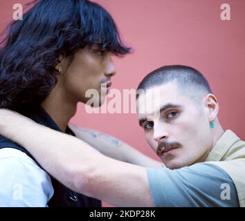 Amore, libertà e coppia lgbtq rilassarsi, abbracciare e legarsi contro un muro in una città, orgogliosi e soddisfatti insieme. Gay, uomini e ritratto di amanti diversi Foto Stock