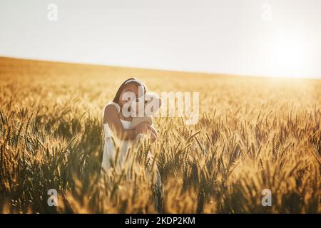 Il vero amore della sua infanzia. Una ragazza carina che gioca con il suo orsacchiotto in un campo di mais. Foto Stock