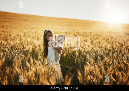 La natura è il suo parco giochi. Ritratto di una ragazza carina che gioca con il suo orsacchiotto in un campo di mais. Foto Stock