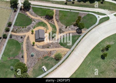 Vista aerea del giardino sul cortile con percorso circolare, prato verde, zona di riposo degli alberi sotto il tetto. Progettazione di paesaggi e giardinaggio. Foto Stock