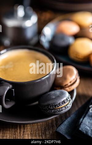Il dolce macaron. Macaron con aroma di caffè e tazza di caffè. Foto Stock