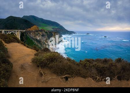 Big sur, California. Ponte storico di Bixby e costa rocciosa in una bella giornata nuvolosa Foto Stock