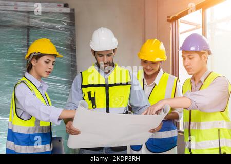 gruppo di lavoratori edili che lavorano insieme discussione guardando piano di lavoro nel processo di costruzione di pianificazione del sito di costruzione Foto Stock