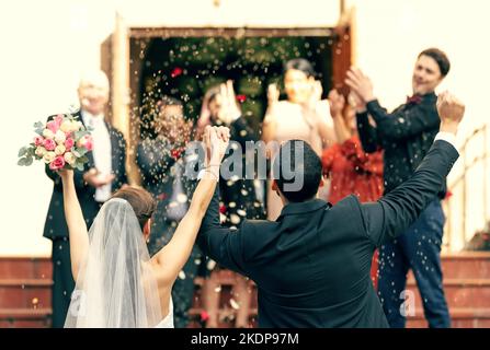 Matrimonio, applausi e coppia in festa con il sostegno di ospiti, amici e familiari. Vista posteriore, sposa e sposo celebrare Foto Stock