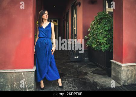 Ritratto di moda di lusso di giovane bella donna in estate vestito blu in ricchi interni Foto Stock