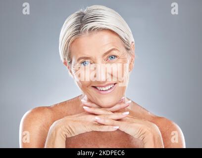 Viso, bellezza e cura della pelle con una donna matura in studio su sfondo grigio per trattamenti antinvecchiamento. Benessere, ritratto e cosmetici con un anziano Foto Stock