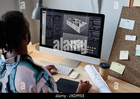 Vista posteriore del designer digitale maschile che crea un modello architettonico 3D sul posto di lavoro, spazio di copia Foto Stock