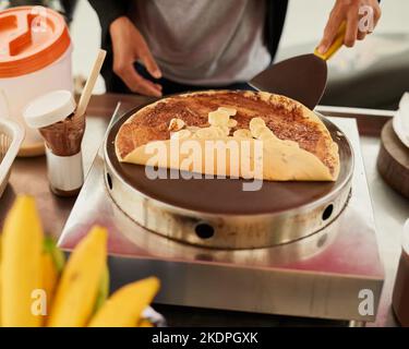 Pronto a soddisfare il vostro desiderio dolce. Un fornitore di cibo non identificabile in Thailandia preparare uno snack gustoso. Foto Stock