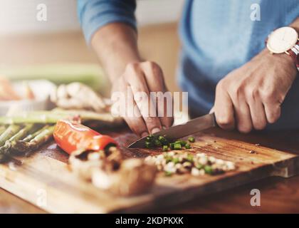 Togliendo una fetta dalla vita sana, un uomo che prepara un pasto sano a casa. Foto Stock