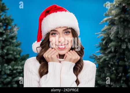 Foto di affascinante bella ragazza vestita babbo natale helper cappello sorridente acquisto x-mas abete isolato sfondo di colore blu Foto Stock