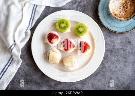 Dessert a tartelletta su sfondo scuro. Prelibatezze tradizionali della cucina francese. Piccoli dessert di frutta. Vista dall'alto Foto Stock