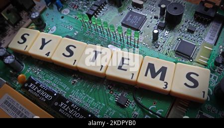 Sistemi - lettere/parole scrabble su un PCB elettronico Foto Stock