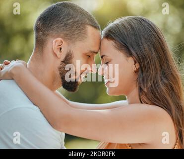 Coppia, amore e la fronte toccare in giardino, parco estivo o cortile all'aperto in Spagna per la cura, la felicità e stile di vita facile insieme. Sorriso, romanticismo Foto Stock